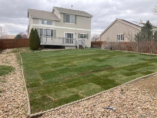 rear view of house featuring a fenced backyard, a yard, and a deck