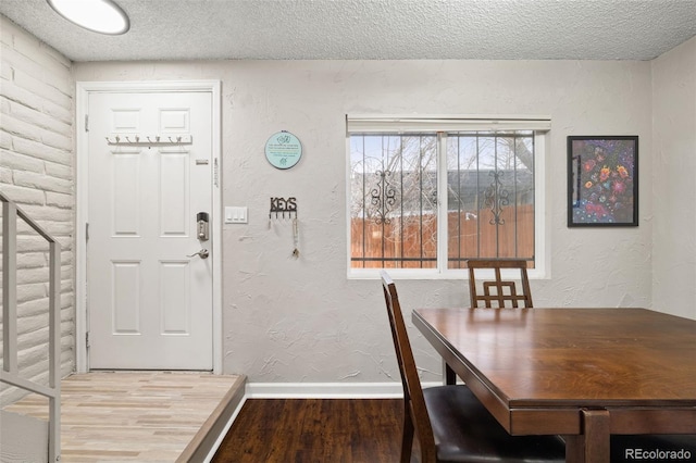 1060 S Parker Rd Unit 19, Denver, CO 80231 - dining area with wood finished floors, baseboards, a textured ceiling, and a textured wall