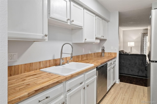 1060 S Parker Rd Unit 19, Denver, CO 80231 - kitchen featuring a sink, stainless steel appliances, wooden counters, and white cabinetry
