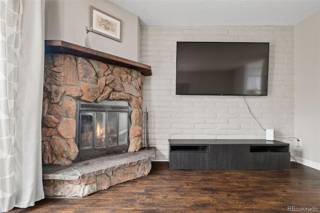 1060 S Parker Rd Unit 19, Denver, CO 80231 - living area with a stone fireplace, wood finished floors, a textured ceiling, and baseboards