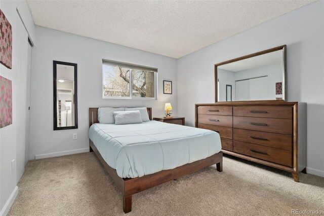 1060 S Parker Rd Unit 19, Denver, CO 80231 - bedroom with light carpet, a textured ceiling, and baseboards