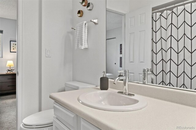 1060 S Parker Rd Unit 19, Denver, CO 80231 - bathroom featuring toilet, a textured ceiling, vanity, and a shower with curtain