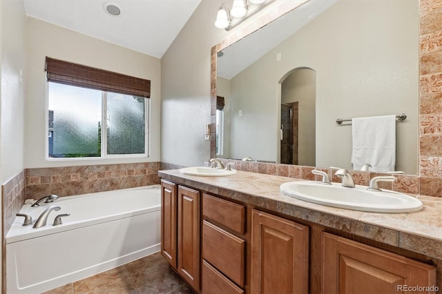 12427 James Ct, Broomfield, CO 80020 - bathroom featuring double vanity, a garden tub, tile patterned flooring, and vaulted ceiling