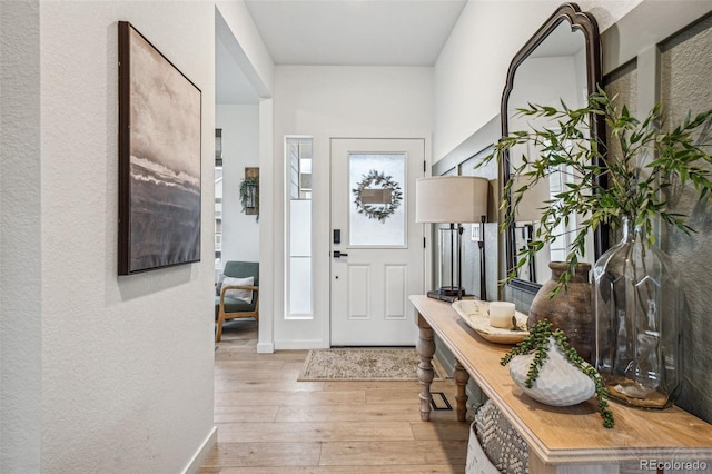 entryway with baseboards and hardwood / wood-style floors