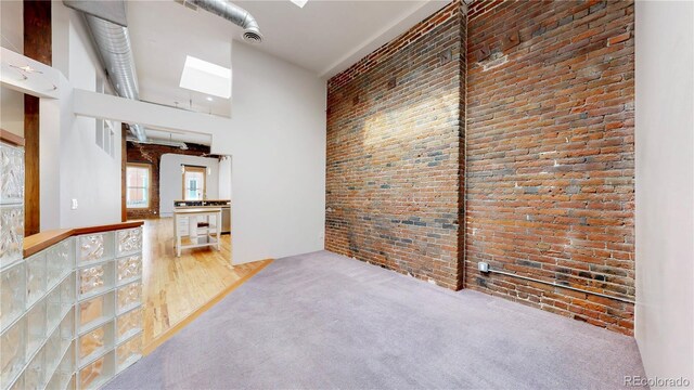 1510 Wazee St Unit 3, Denver, CO 80202 - empty room with brick wall, a high ceiling, and carpet