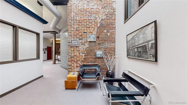 1510 Wazee St Unit 3, Denver, CO 80202 - hallway featuring a high ceiling, baseboards, carpet flooring, and brick wall