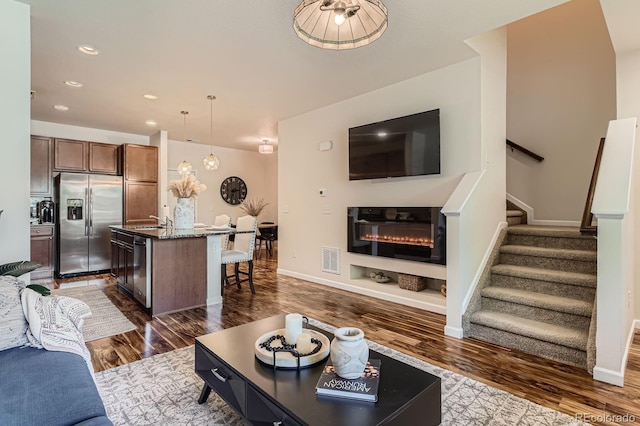 504 E Dry Creek Pl, Littleton, CO 80122 - living area with stairway, dark wood-type flooring, a glass covered fireplace, baseboards, and recessed lighting