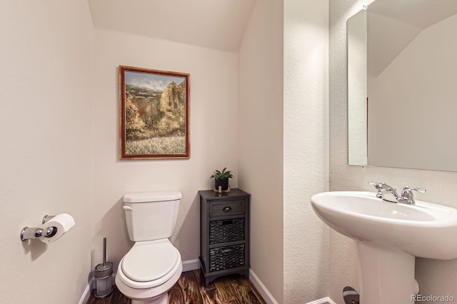 504 E Dry Creek Pl, Littleton, CO 80122 - bathroom featuring wood finished floors, toilet, baseboards, lofted ceiling, and a sink