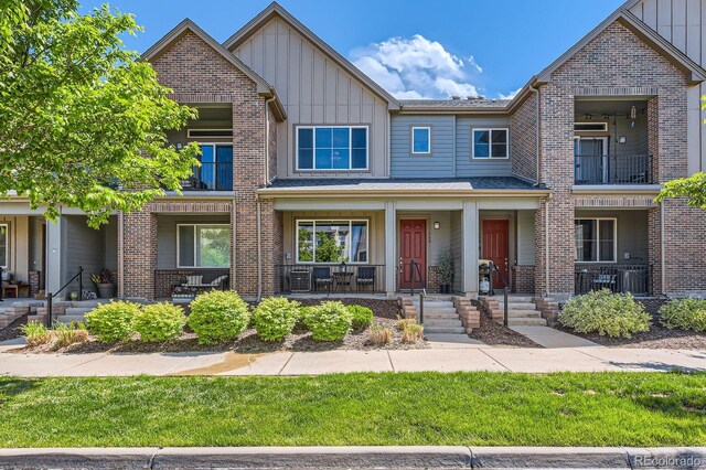 504 E Dry Creek Pl, Littleton, CO 80122 - view of front facade with board and batten siding, a porch, and brick siding