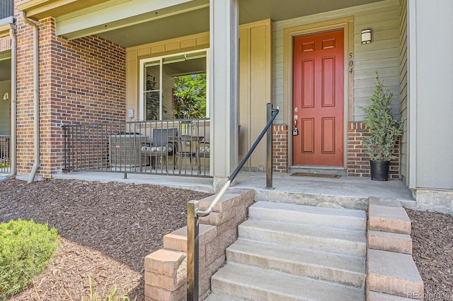 504 E Dry Creek Pl, Littleton, CO 80122 - view of exterior entry featuring brick siding and a porch