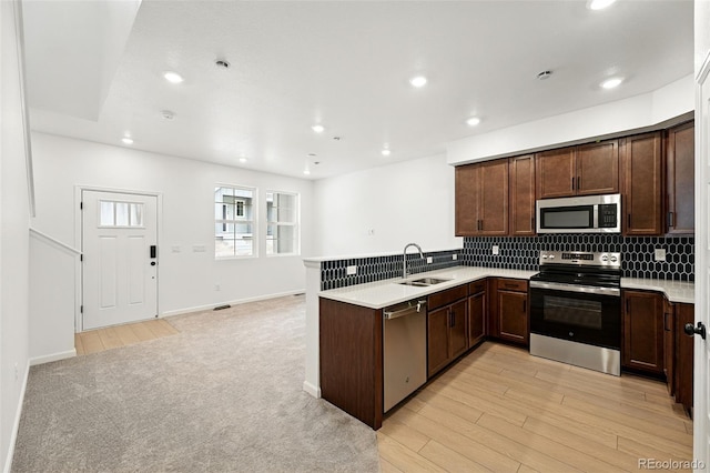 17117 W 91st Ln, Arvada, CO 80007 - kitchen featuring appliances with stainless steel finishes, a sink, a peninsula, decorative backsplash, and recessed lighting