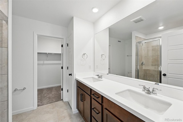 17117 W 91st Ln, Arvada, CO 80007 - bathroom featuring a stall shower, double vanity, tile patterned floors, a spacious closet, and toilet