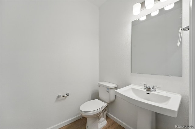 17117 W 91st Ln, Arvada, CO 80007 - bathroom with wood finished floors, toilet, baseboards, and a sink