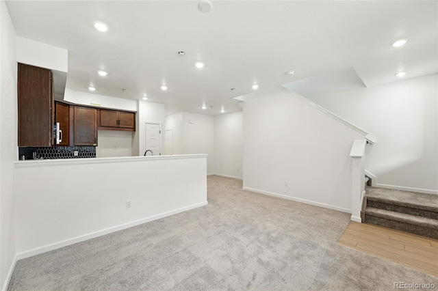 17117 W 91st Ln, Arvada, CO 80007 - unfurnished living room with recessed lighting, stairs, baseboards, light wood-style floors, and light colored carpet