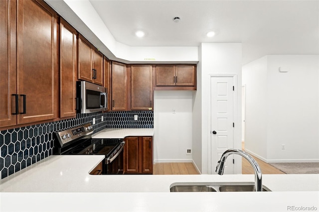 17117 W 91st Ln, Arvada, CO 80007 - kitchen with appliances with stainless steel finishes, a sink, decorative backsplash, light countertops, and recessed lighting