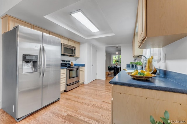 445 Wintery Cir, Colorado Springs, CO 80919 - kitchen featuring stainless steel appliances, light brown cabinets, light wood finished floors, and a raised ceiling
