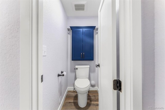 445 Wintery Cir, Colorado Springs, CO 80919 - bathroom featuring wood finished floors, baseboards, toilet, and a textured wall