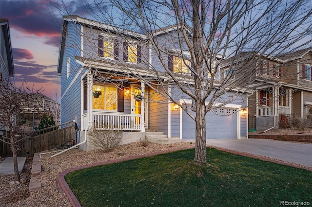 traditional home featuring concrete driveway, a yard, a porch, and an attached garage