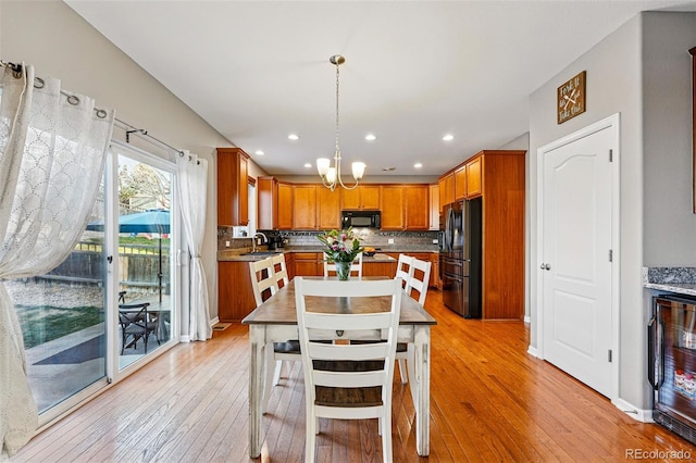 dining room featuring a chandelier, wine cooler, recessed lighting, and light wood-style floors