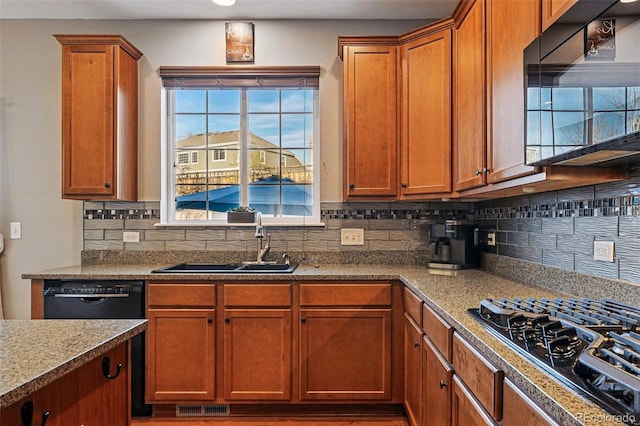 kitchen with visible vents, a sink, brown cabinetry, black appliances, and decorative backsplash