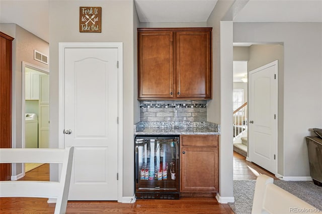 bar featuring tasteful backsplash, visible vents, wine cooler, baseboards, and dark wood-style floors
