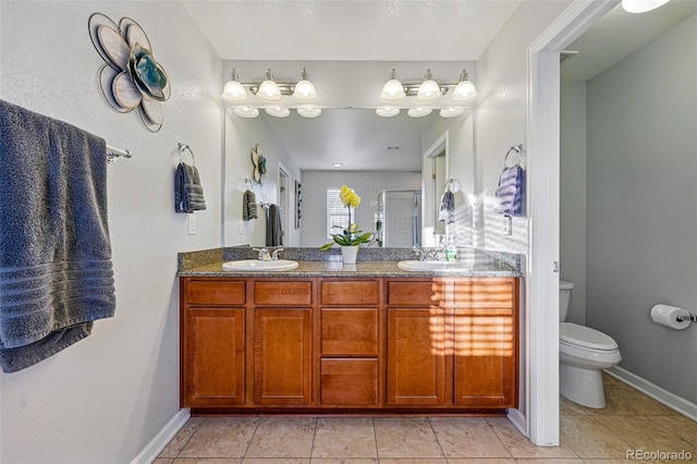full bath featuring a shower stall, double vanity, a sink, and toilet