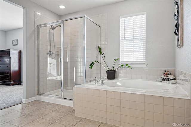bathroom with a stall shower, a garden tub, and tile patterned floors