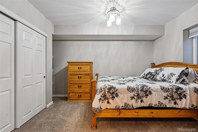 carpeted bedroom with a textured ceiling and a closet
