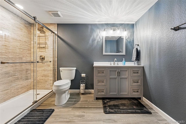 full bath featuring a textured wall, a shower stall, and toilet