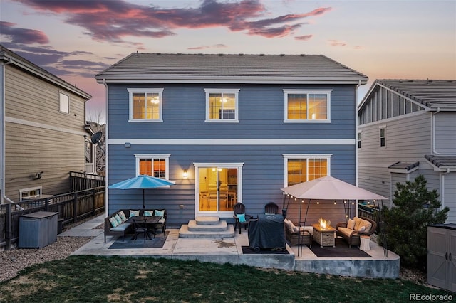 rear view of house featuring entry steps, a tile roof, fence, and a patio