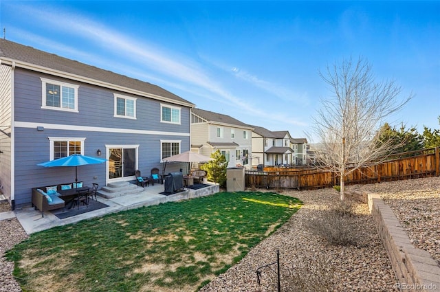 rear view of property featuring entry steps, a yard, a fenced backyard, a patio, and a residential view