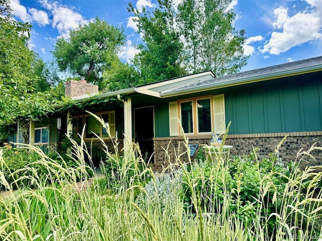 1315 Tipperary St, Boulder, CO 80303 - view of property exterior featuring board and batten siding, a chimney, and brick siding