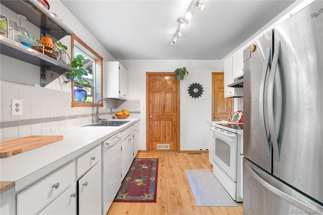 1315 Tipperary St, Boulder, CO 80303 - kitchen with white appliances, range hood, decorative backsplash, light wood-style flooring, and white cabinets