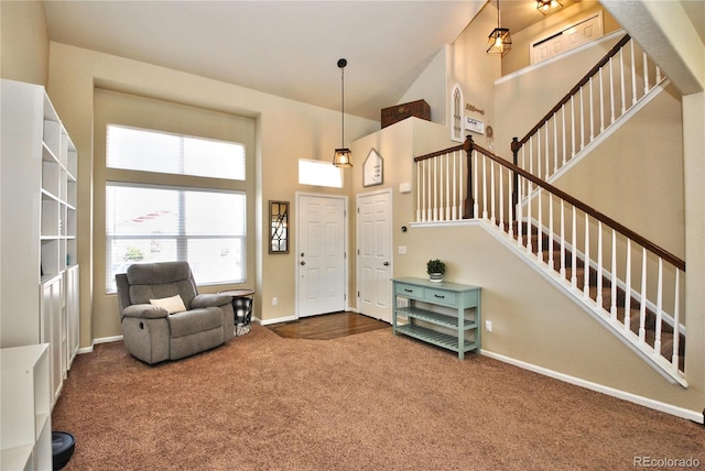 carpeted entrance foyer featuring a towering ceiling