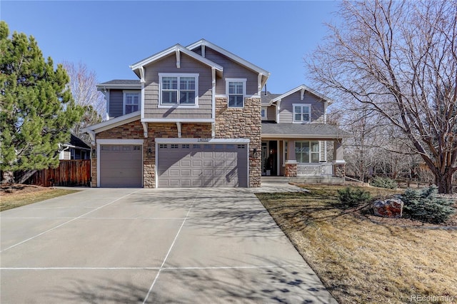 craftsman-style house featuring a garage, concrete driveway, stone siding, covered porch, and fence