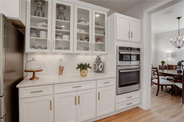 kitchen with light countertops, appliances with stainless steel finishes, backsplash, and white cabinets