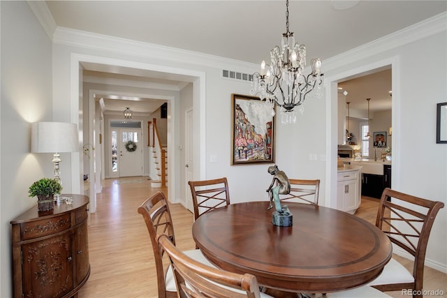 dining space featuring crown molding, plenty of natural light, visible vents, and light wood-style floors