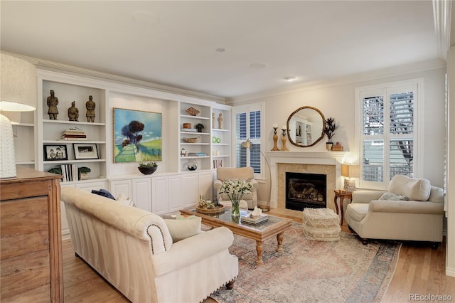 living area featuring light wood-style flooring, a fireplace, and ornamental molding