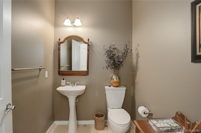 half bathroom featuring toilet, baseboards, and tile patterned floors