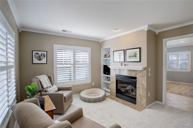 living room with ornamental molding, a tile fireplace, visible vents, and plenty of natural light