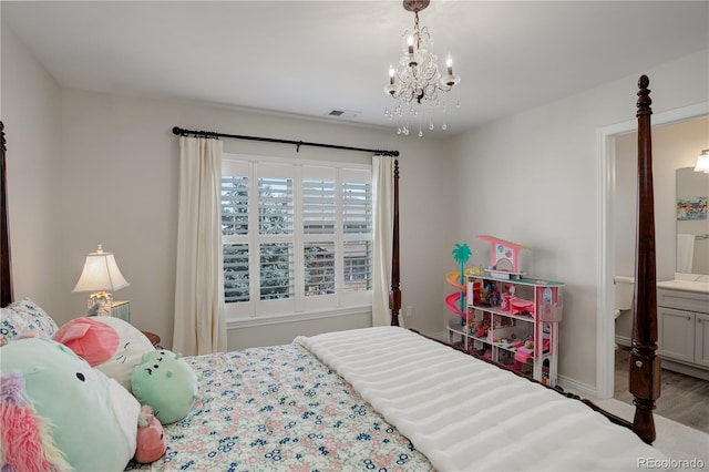 bedroom featuring baseboards, ensuite bathroom, visible vents, and a notable chandelier