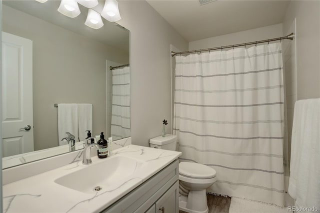 bathroom with a shower with curtain, vanity, toilet, and wood finished floors