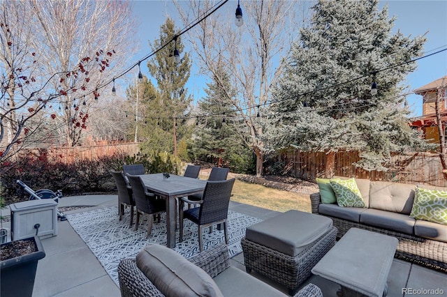 view of patio / terrace with outdoor dining space, fence, and an outdoor hangout area