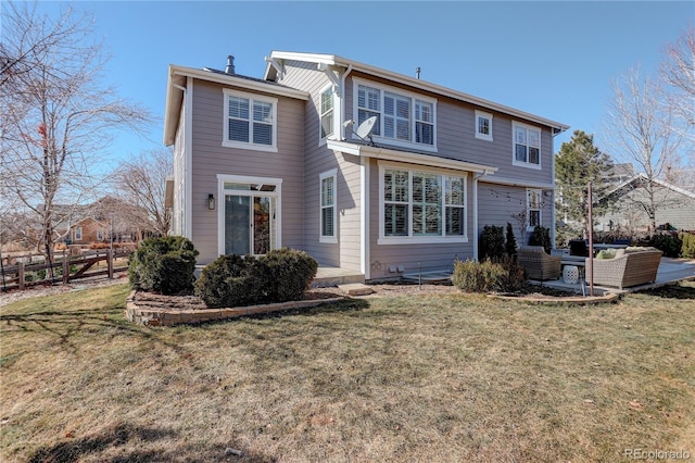 rear view of property featuring a lawn, outdoor lounge area, and fence