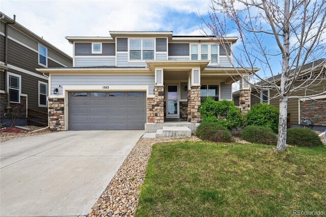 13113 W 73rd Ave, Arvada, CO 80005 - prairie-style home featuring an attached garage, driveway, stone siding, and a front yard
