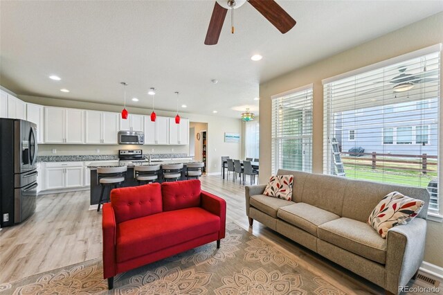 13113 W 73rd Ave, Arvada, CO 80005 - living room featuring light wood finished floors, baseboards, recessed lighting, and ceiling fan