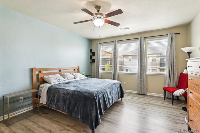 13113 W 73rd Ave, Arvada, CO 80005 - bedroom featuring light wood-style floors, visible vents, a ceiling fan, and baseboards