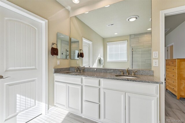 13113 W 73rd Ave, Arvada, CO 80005 - bathroom featuring a tile shower, a sink, visible vents, and double vanity