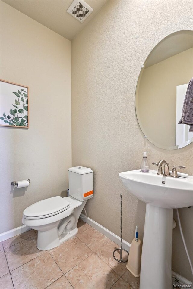 13113 W 73rd Ave, Arvada, CO 80005 - half bath featuring visible vents, toilet, baseboards, and tile patterned floors