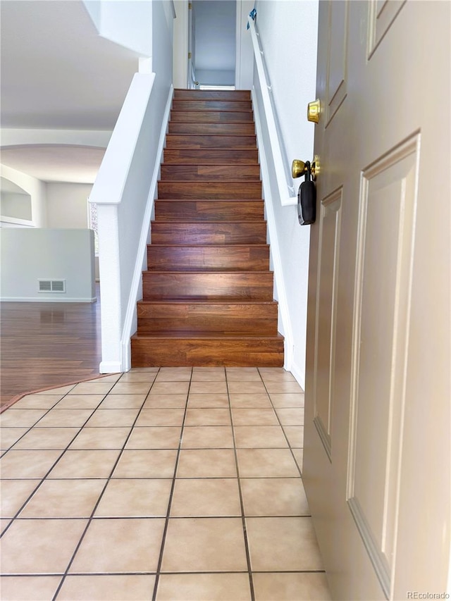 20401 E Chenango Pl, Aurora, CO 80015 - staircase featuring tile patterned flooring and arched walkways